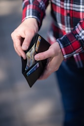 person holding black and orange box