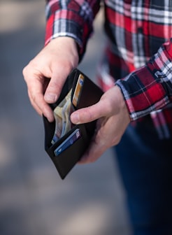 person holding black and orange box