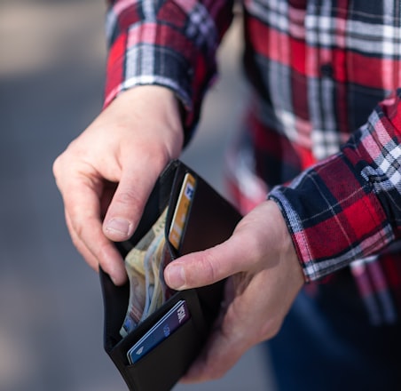 person holding black and orange box