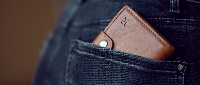 black leather wallet on blue denim jeans