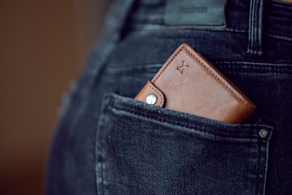 black leather wallet on blue denim jeans