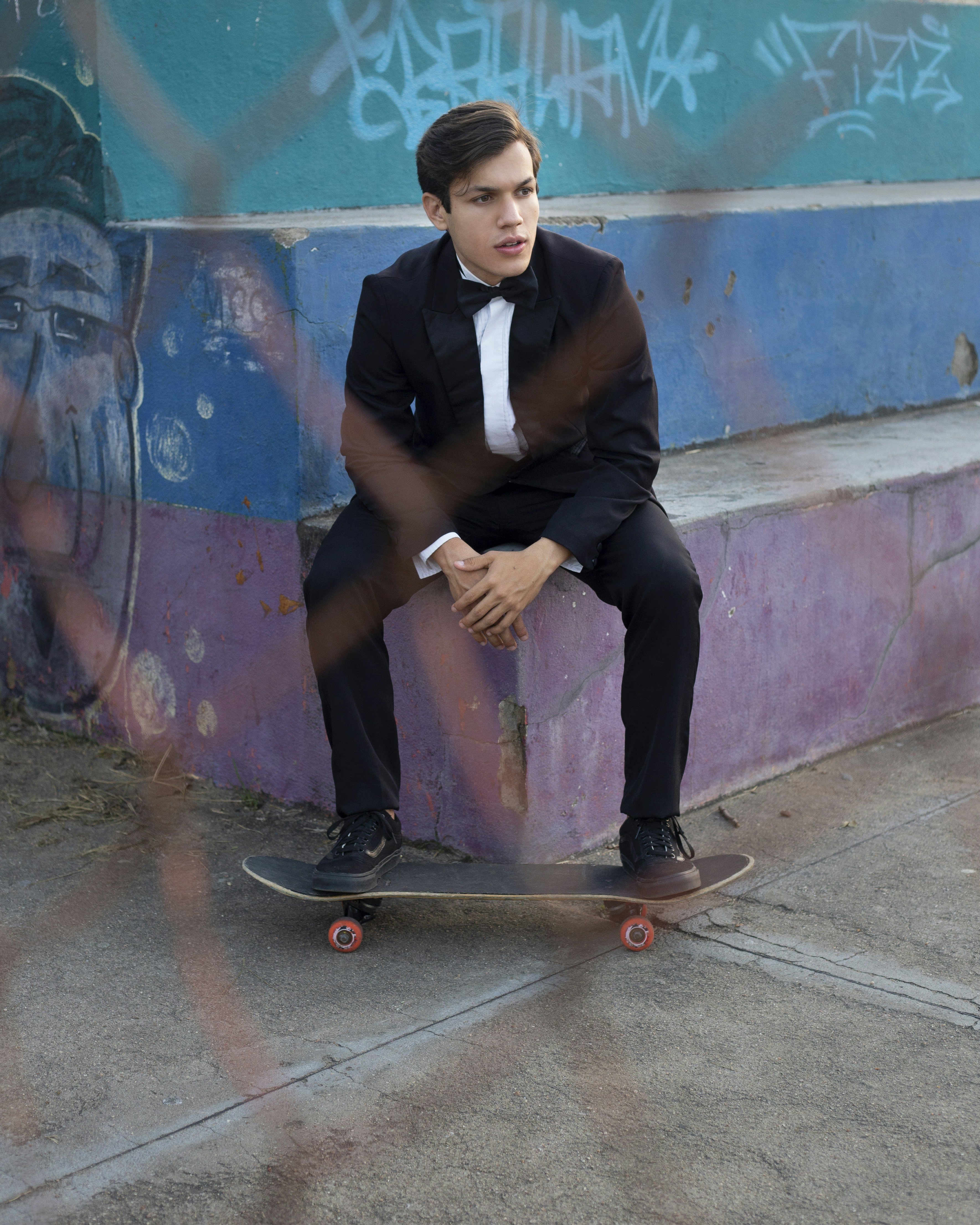 man in black vest sitting on brown wooden seat