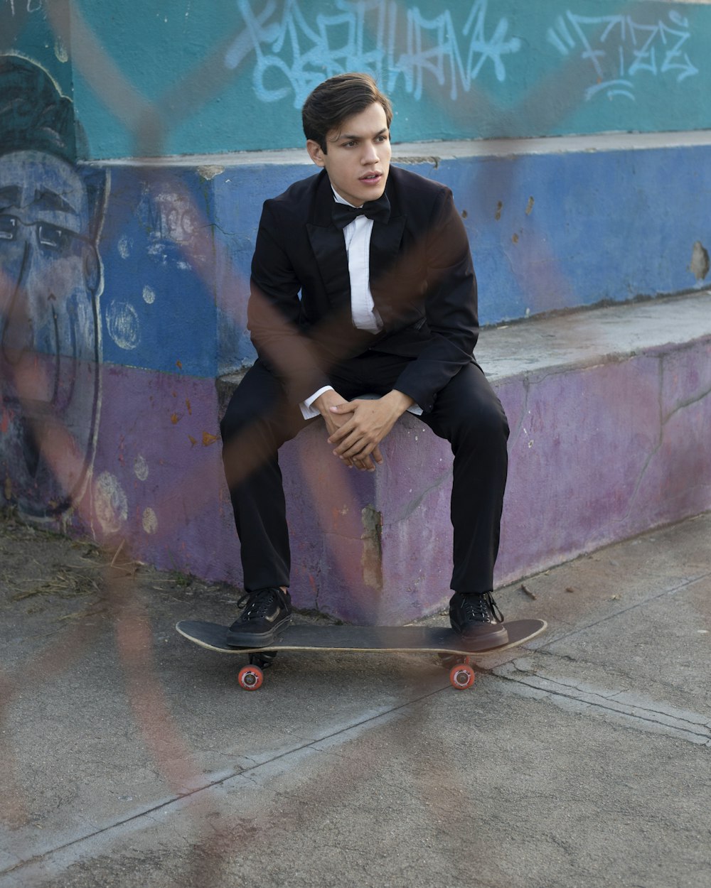 man in black vest sitting on brown wooden seat