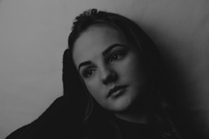 A quiet, moody portrait of a person staring into distance, caught between struggle and calm.