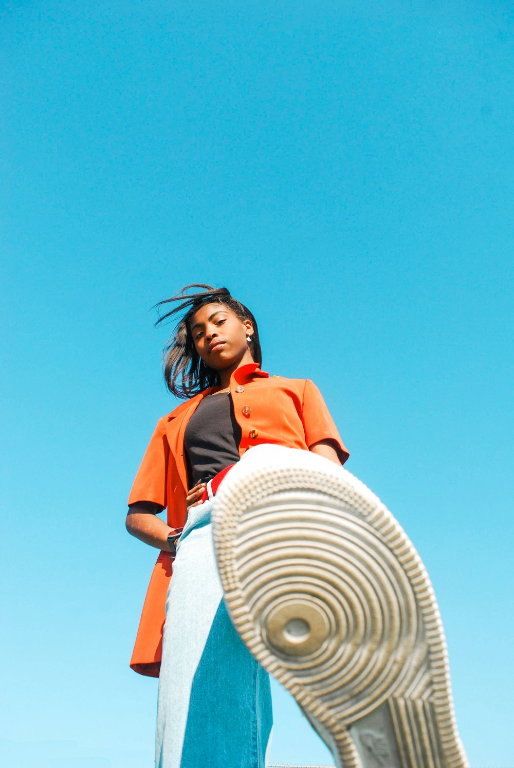 woman in red shirt and white hat standing under blue sky during daytime