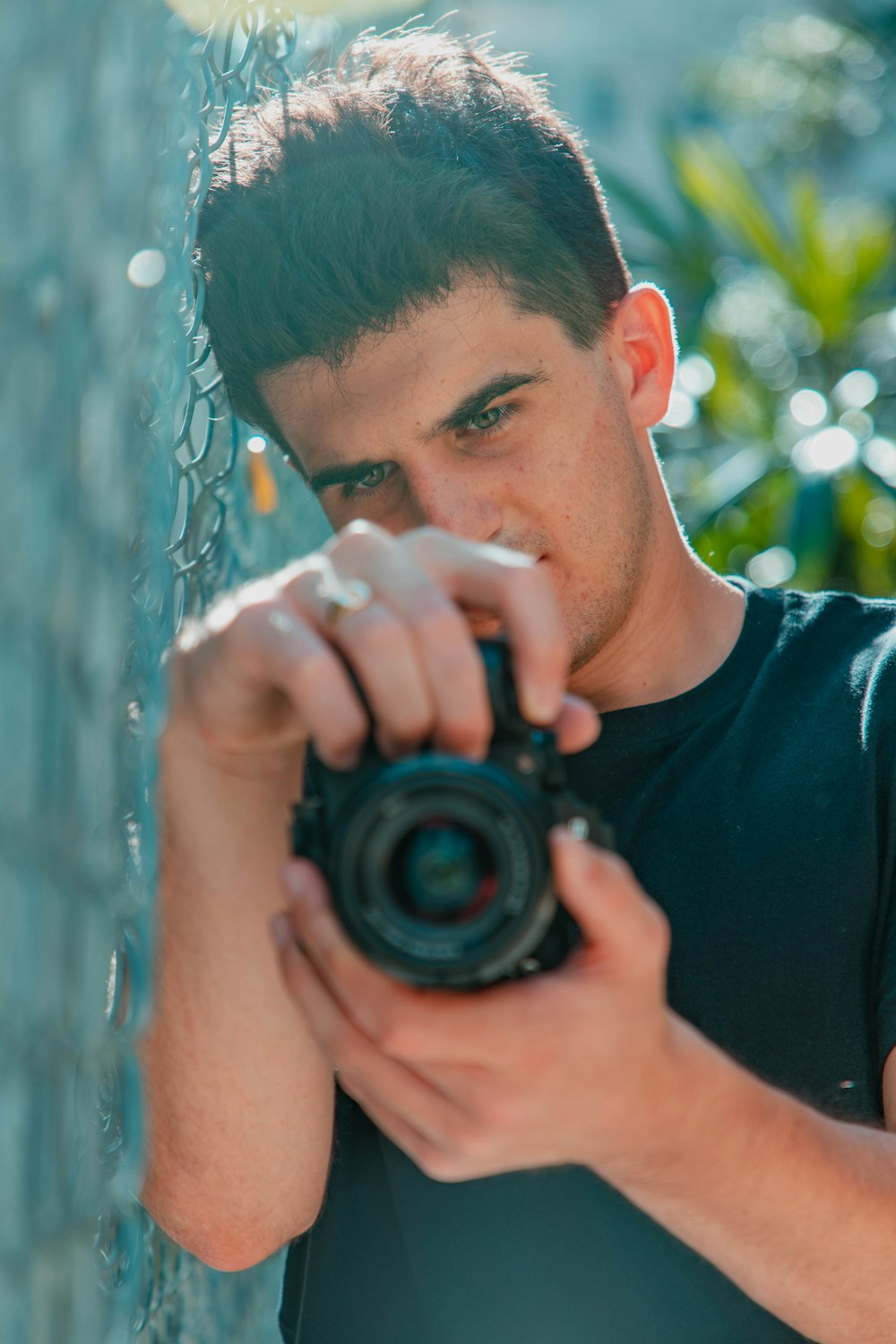 man in black crew neck shirt holding black camera