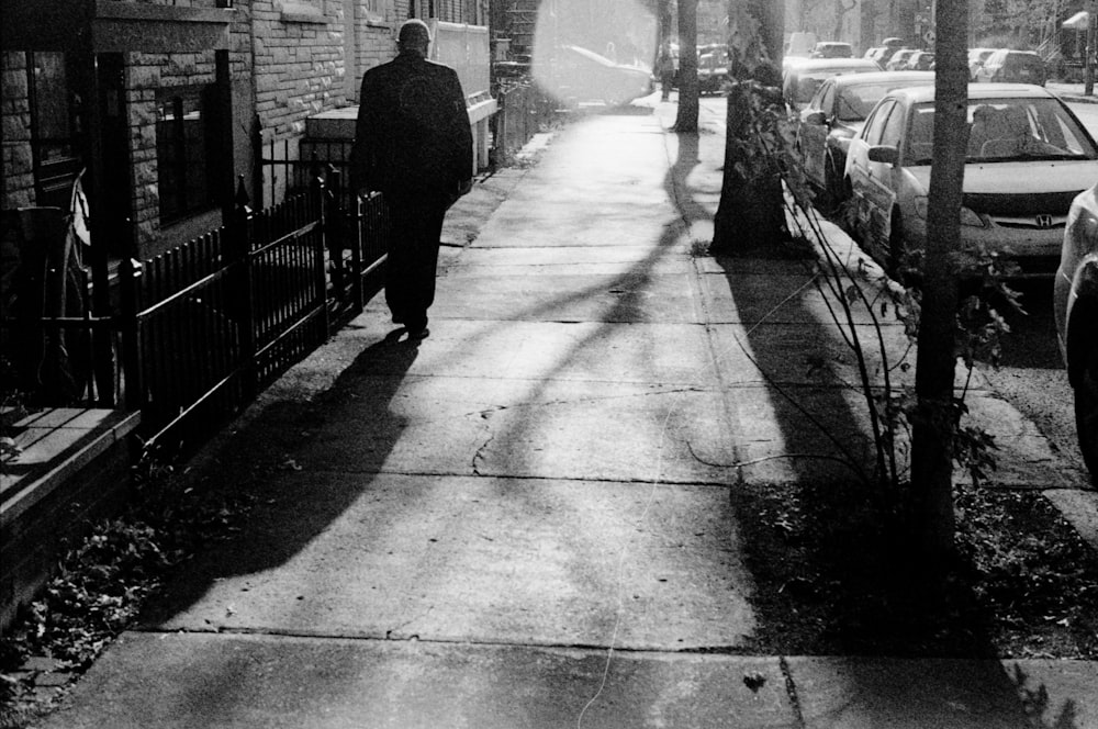 man walking on sidewalk during daytime