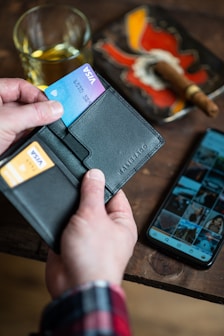 black leather bifold wallet on persons hand