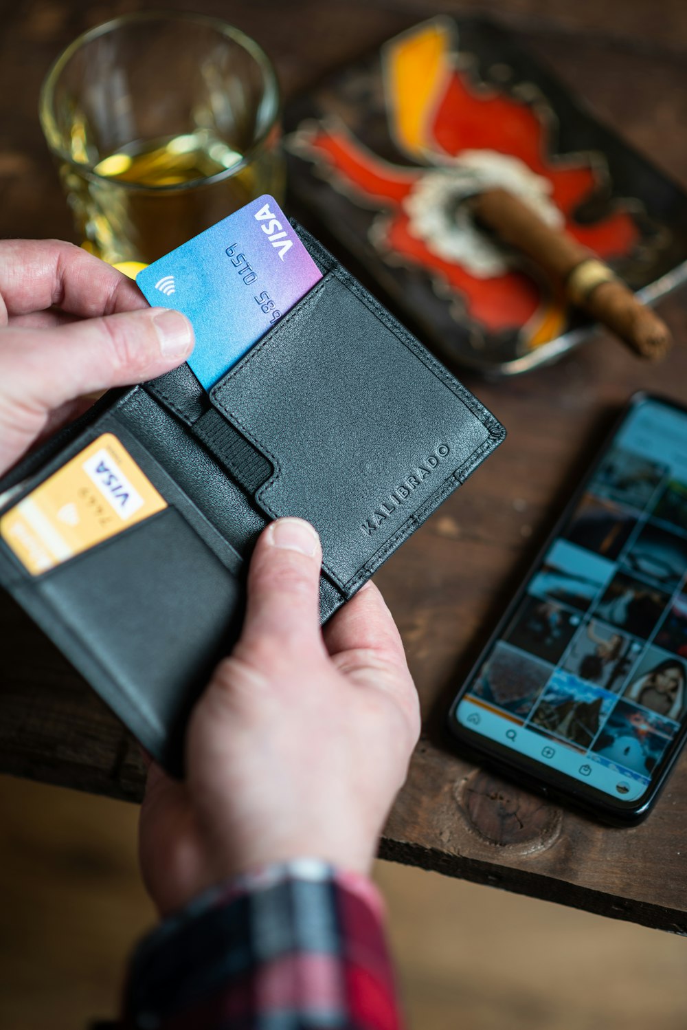 black leather bifold wallet on persons hand