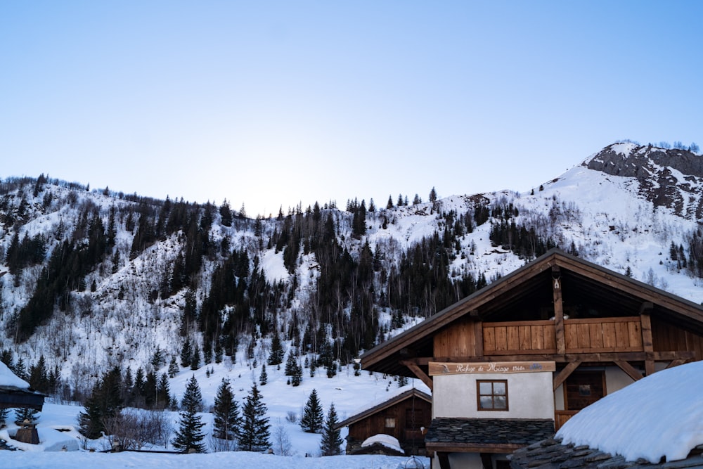 Casa de madera marrón en una montaña cubierta de nieve durante el día