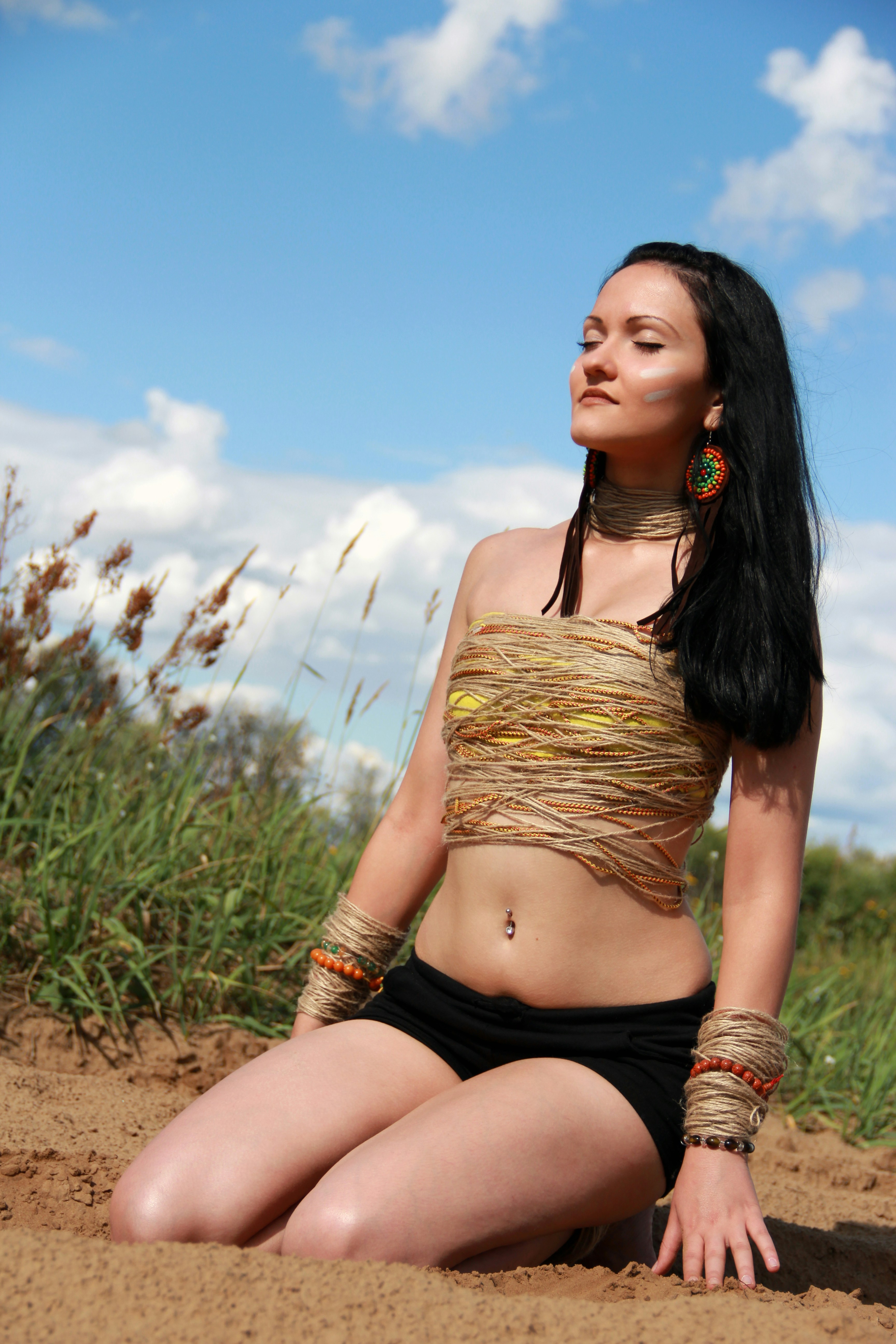 mulher no sutiã marrom e calcinha preta sentada no campo verde da grama durante o dia