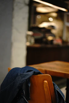 A cozy cobalt blue t-shirt draped over a wooden chair with soft natural light.