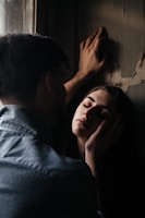 An intimate scene showing the two lovers reaching out to each other across a dimly lit room.