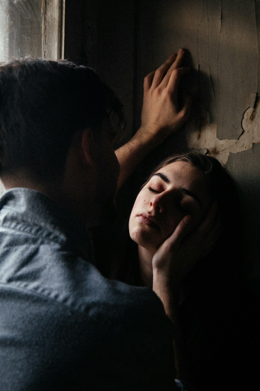 man in blue shirt kissing womans cheek