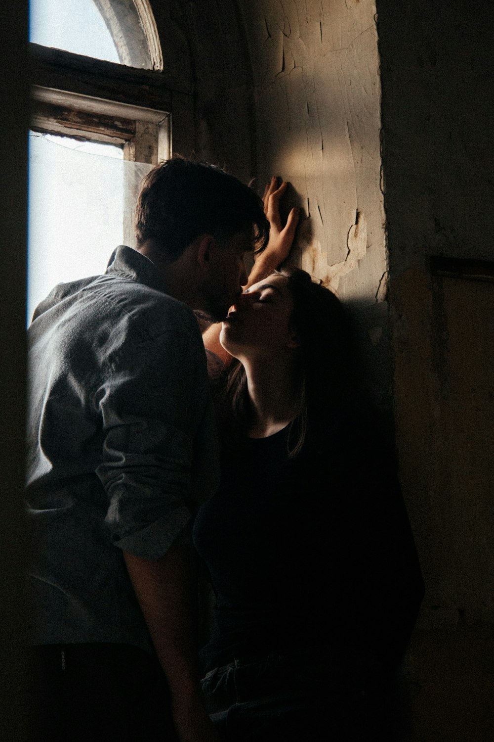 man in gray shirt hugging woman in black tank top