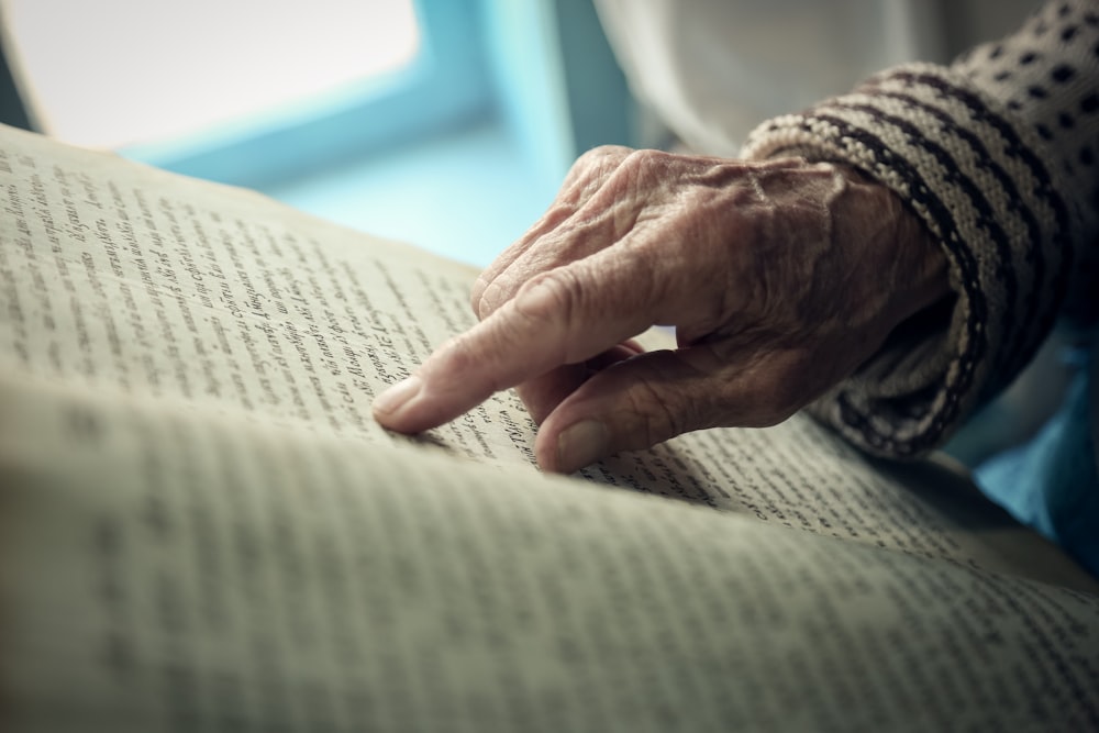 persons hand on white textile