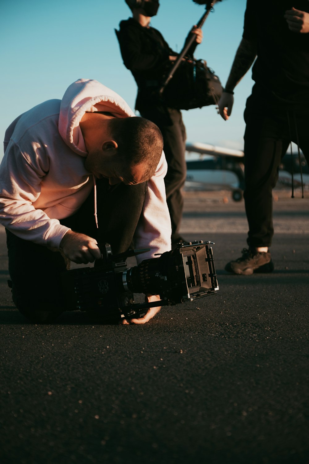 man in white hoodie carrying black dslr camera