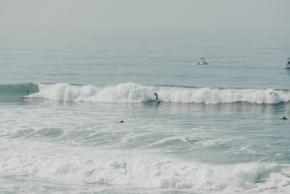 people surfing on sea waves during daytime