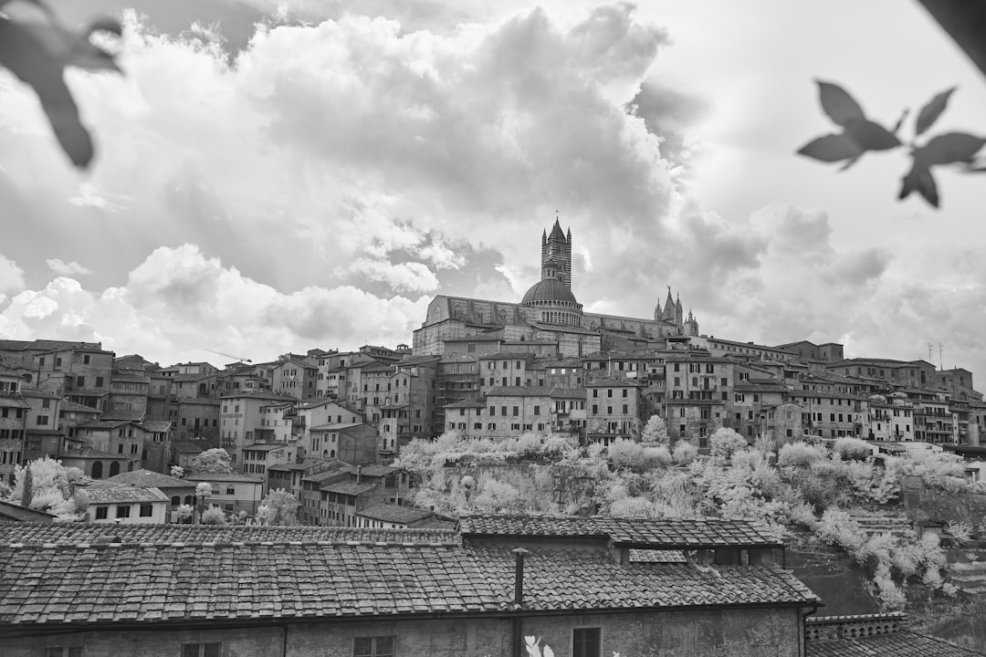 grayscale photo of city buildings under cloudy sky