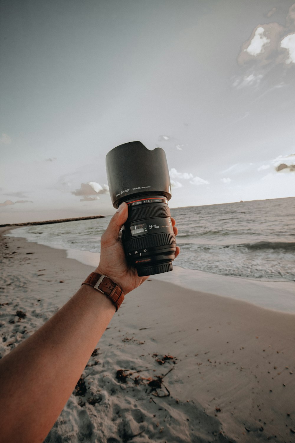 person holding black camera lens