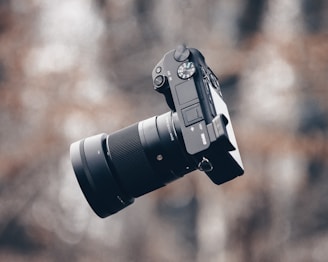 black dslr camera on brown wooden table
