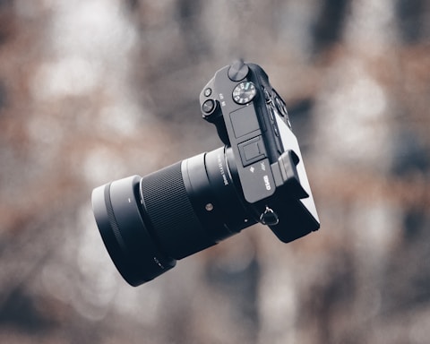 black dslr camera on brown wooden table