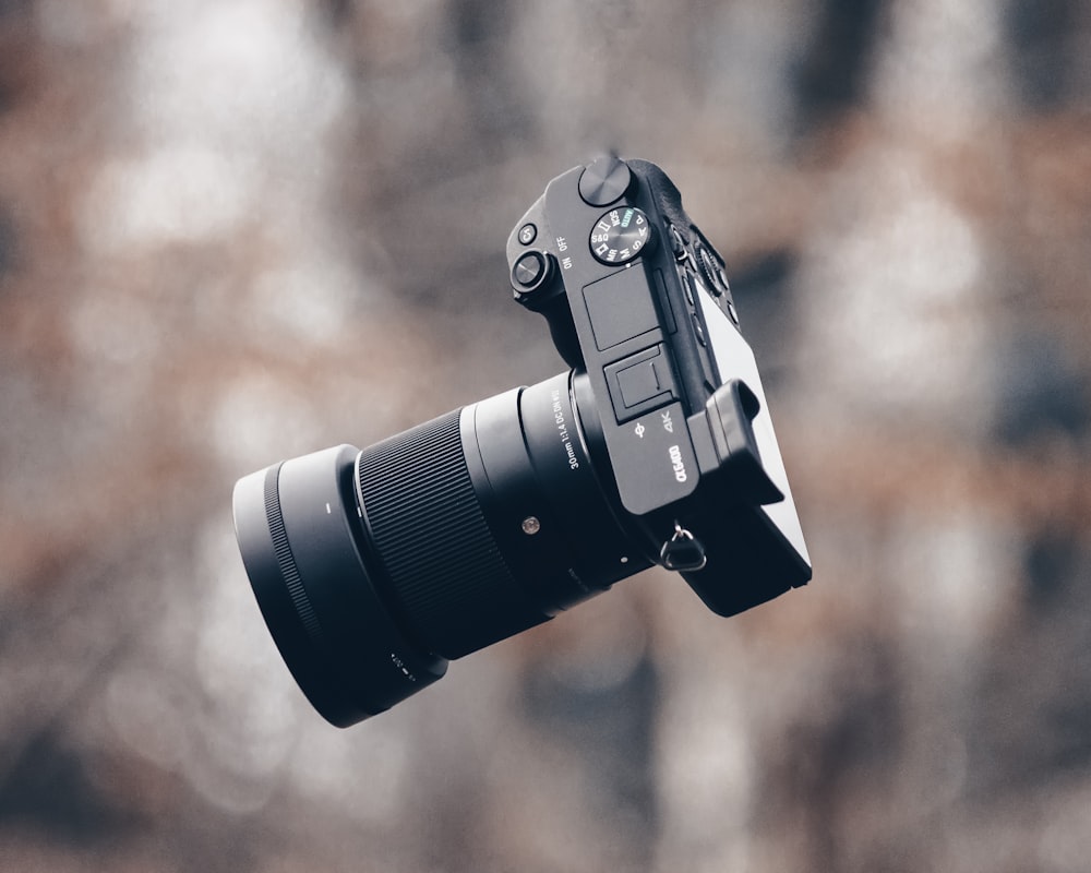 black dslr camera on brown wooden table