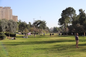 Diverse group of people enjoying a community park surrounded by apartment buildings.