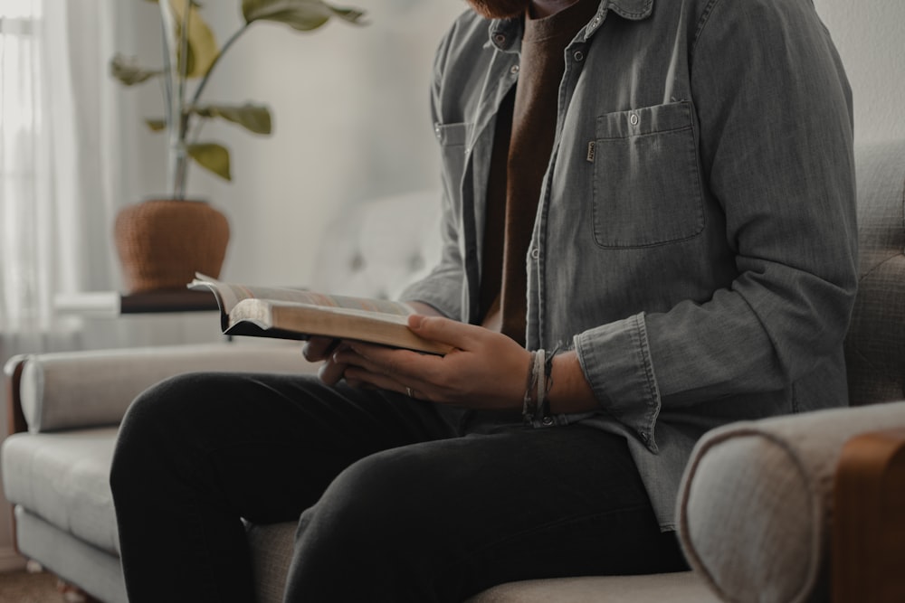 woman in blue denim jacket and black pants sitting on couch