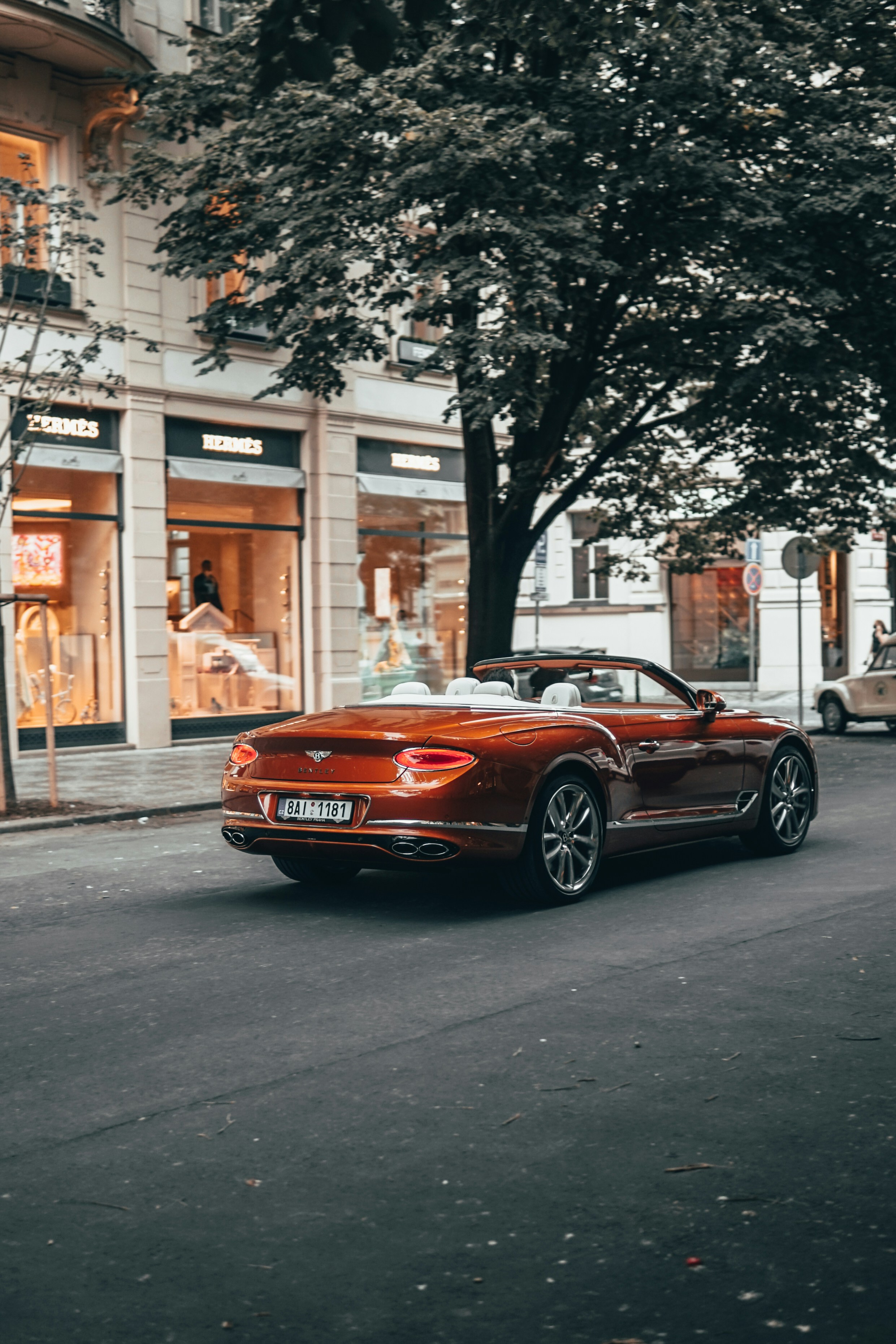 red mercedes benz coupe parked on sidewalk during daytime