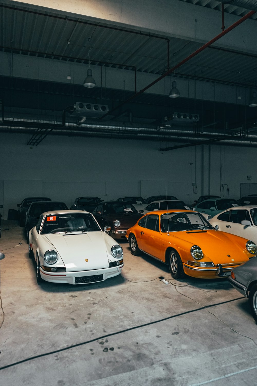 white and yellow porsche 911 parked on parking lot