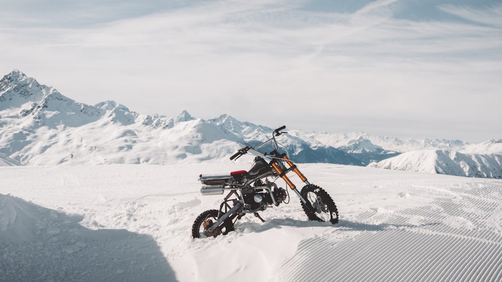 man riding motocross dirt bike on snow covered field during daytime