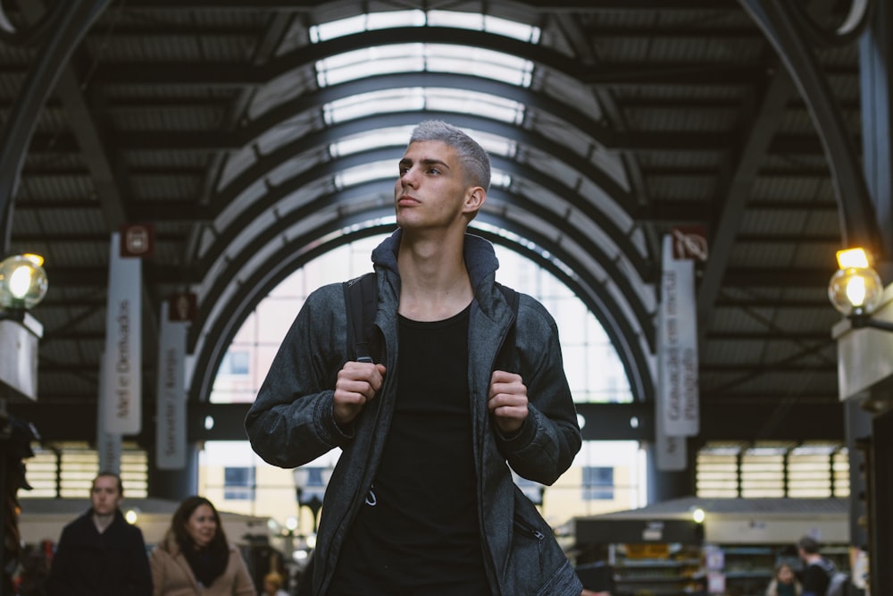 man in black jacket standing near people