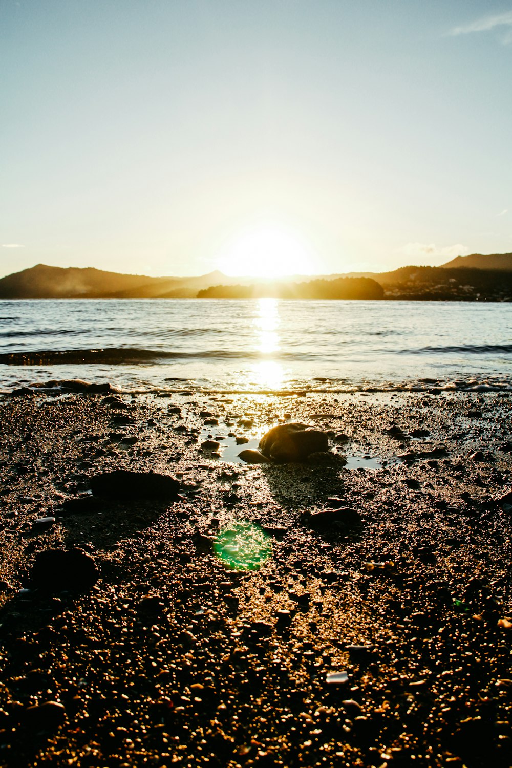 sea waves crashing on shore during sunset