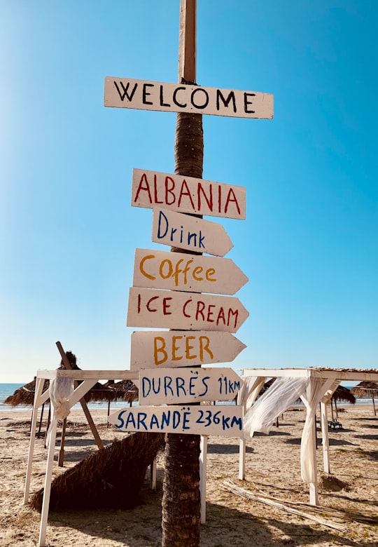 brown wooden welcome to the beach signage in Durrës Albania