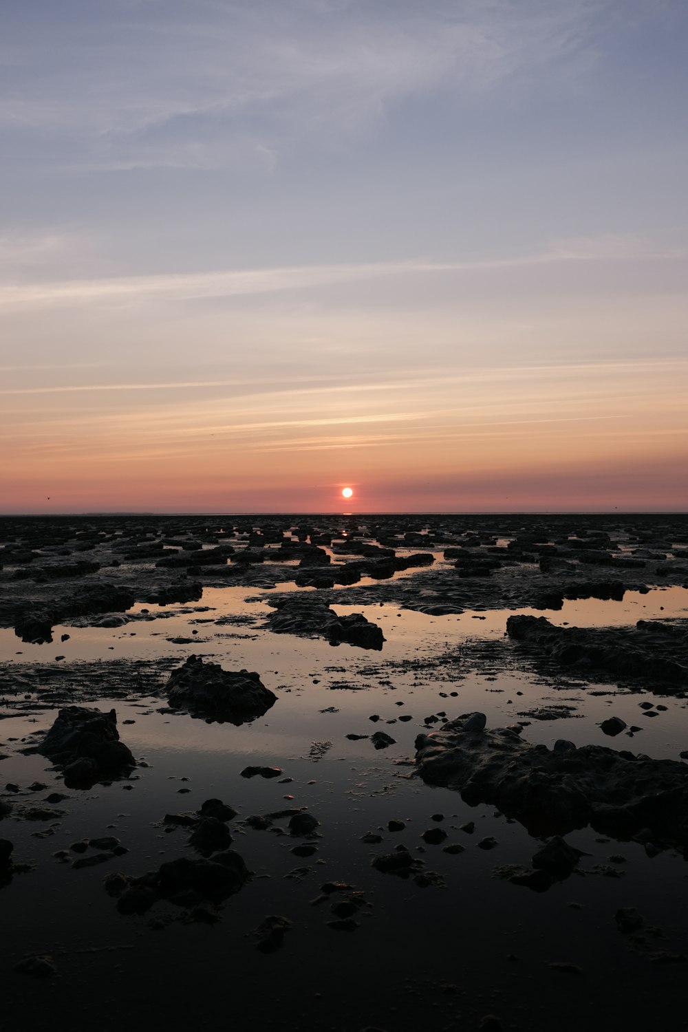rochas no corpo de água durante o pôr do sol
