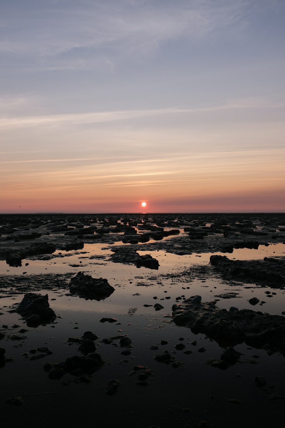 Rocas en el cuerpo de agua durante la puesta del sol