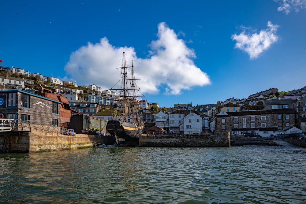 brown and white concrete buildings beside body of water under blue sky during daytime