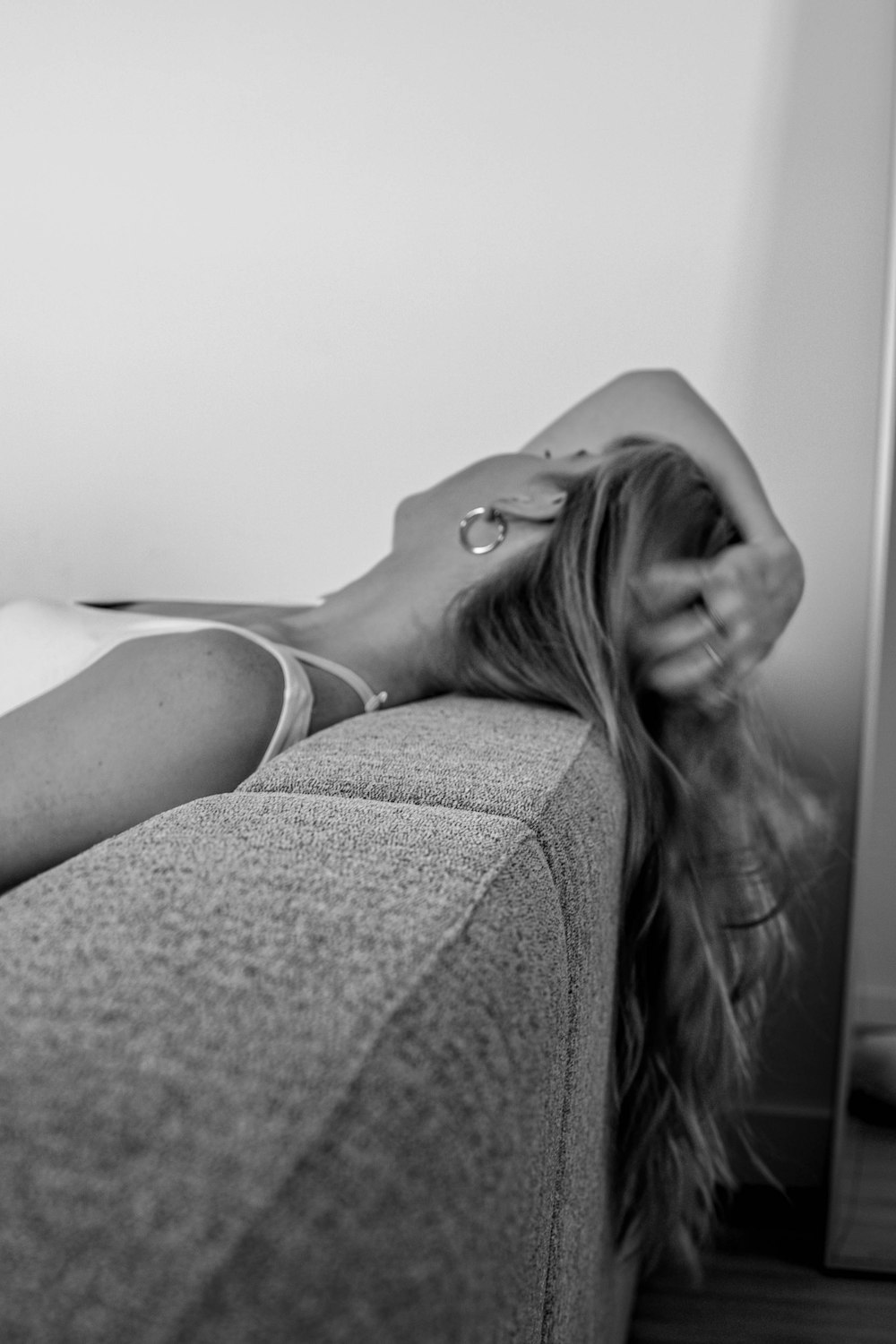 grayscale photo of woman lying on bed