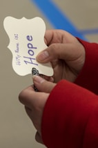 A close-up of a young girl holding a handmade sign that says 'Hope'.