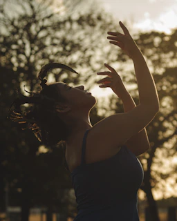 A radiant figure dancing joyfully under a golden sunrise, symbolizing new beginnings