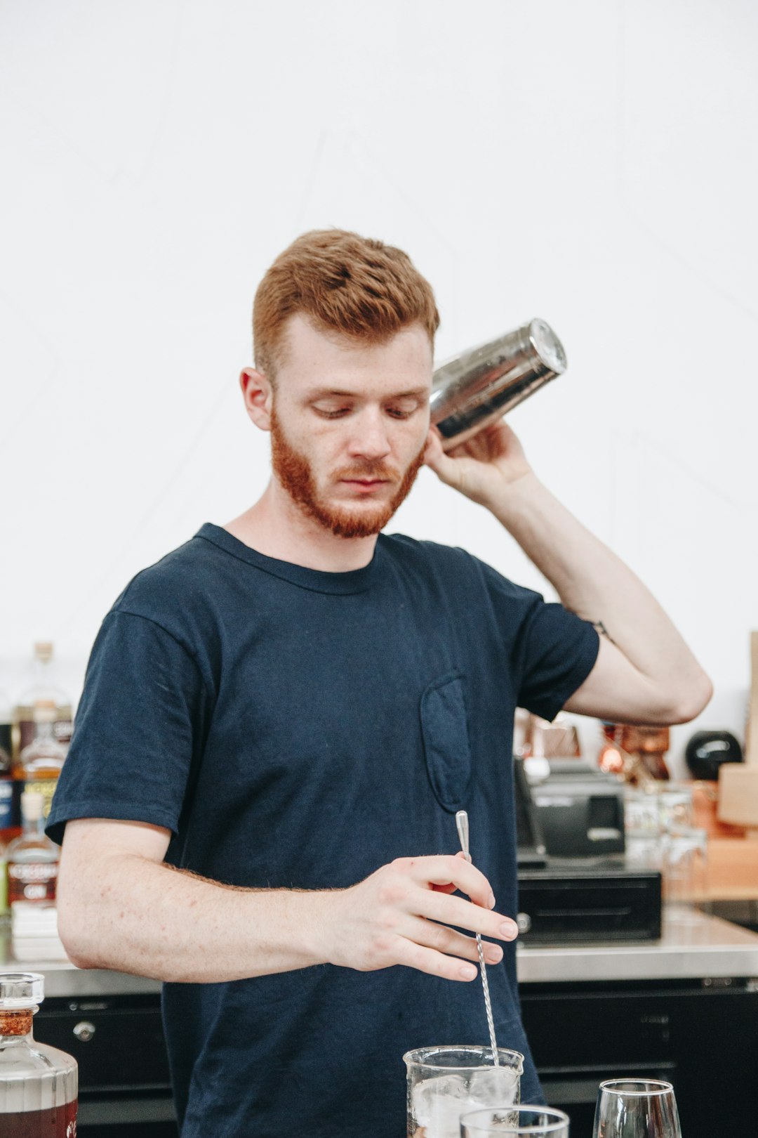 man in black crew neck t-shirt holding stainless steel vacuum flask