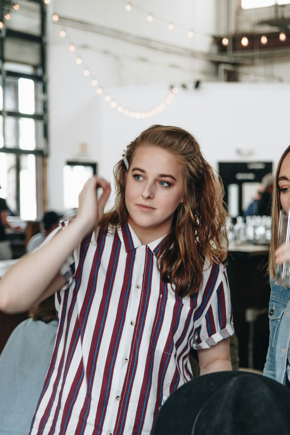 girl in white and red striped button up shirt