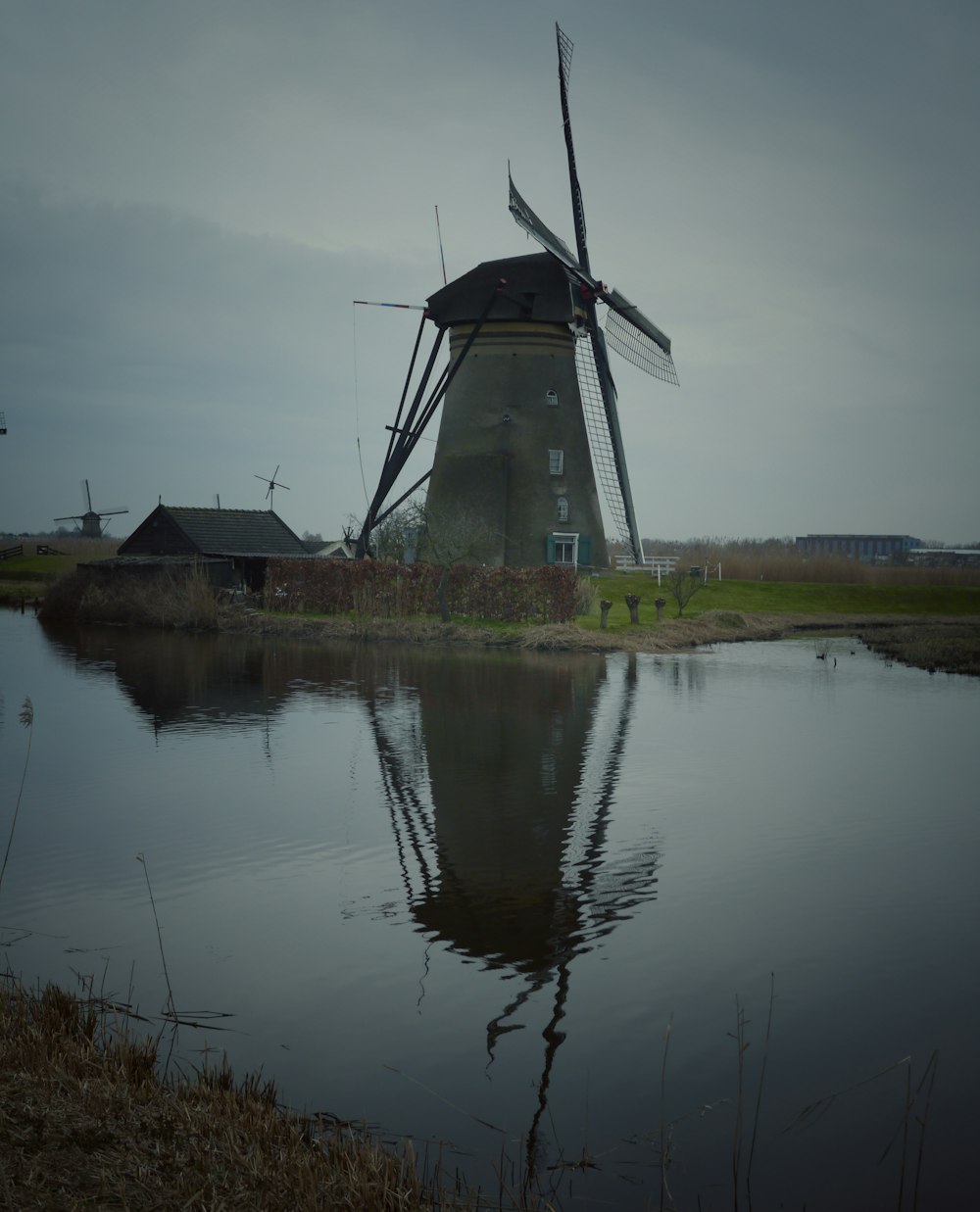 windmill near body of water during daytime