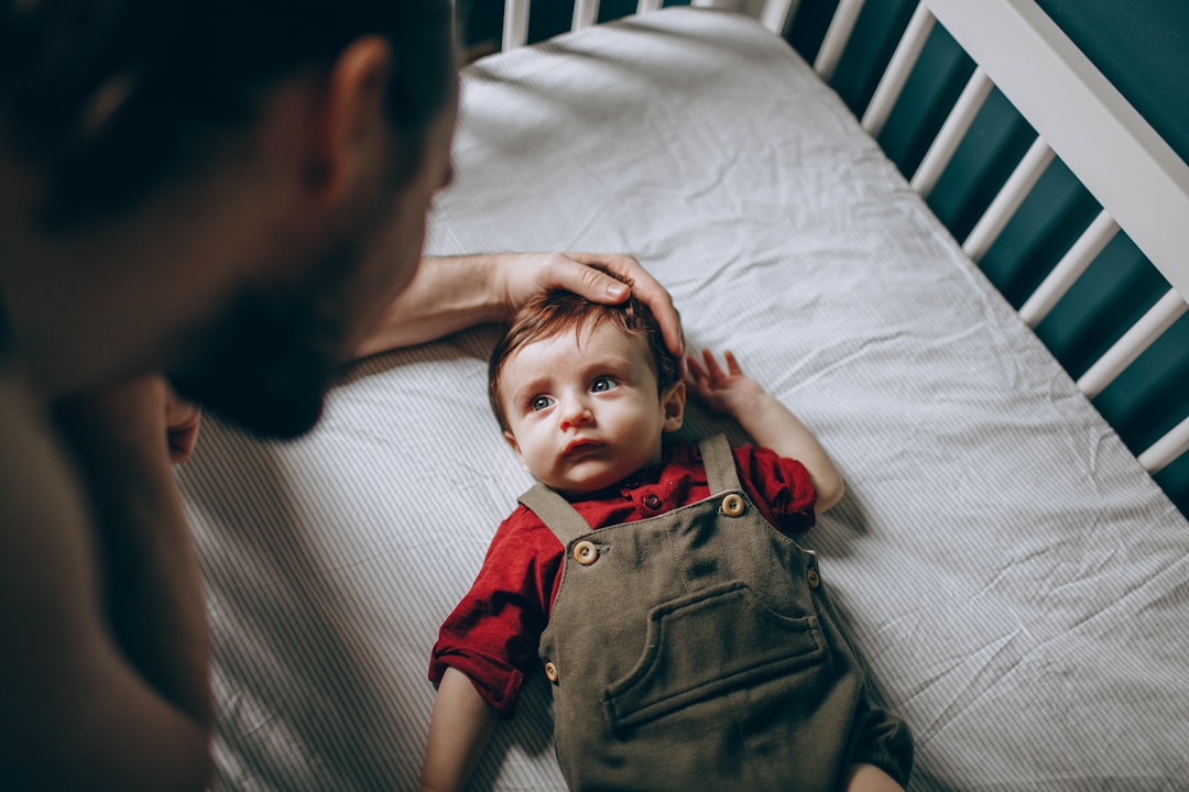 boy in red polo shirt lying on bed