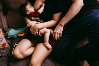A cozy scene of a parent reading a digital guide on a tablet while holding their newborn.
