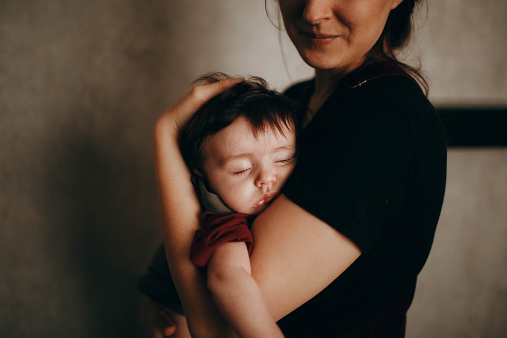 woman in black shirt hugging girl in red shirt