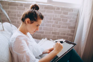 woman in white long sleeve shirt reading book