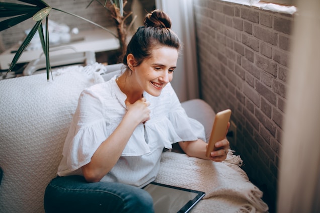 A smiling learner practicing a new language on a tablet in a cozy home setting.