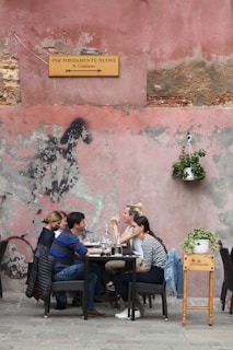 Des gens assis sur des chaises près d'une table dans un café italien